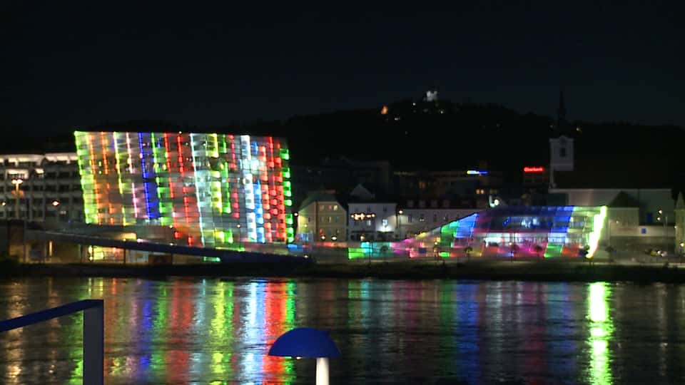 Still from the Ars Electronica Center Facade with colorful lines forming abstract shapes and patterns on the building's LED exterior.