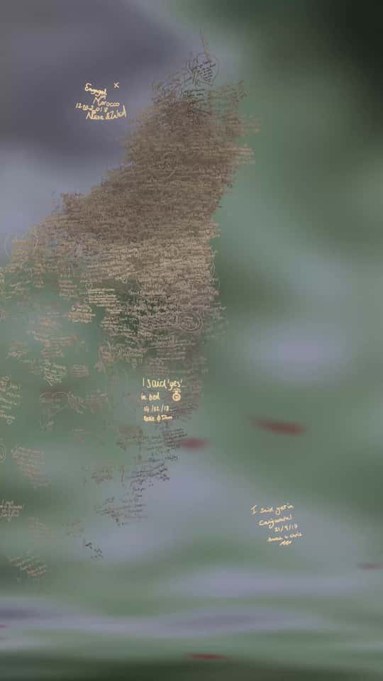 Still of the VASHI Love Wall installation showing a colorful cloud of animated particles forming hand-drawn shapes and messages.